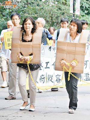 梁靄玲（前左）和李美笑（前右）扮囚犯，抗議署方粗暴打壓工會。	（蘇文傑攝）