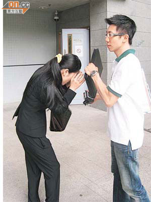 被告楊嘉敏（左）在丈夫陪同下，離開法院。