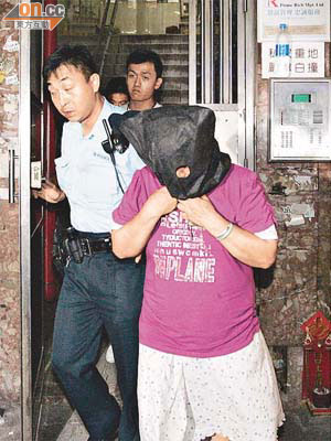涉案婦人被警員蒙頭帶署調查。	（邱國賢攝）