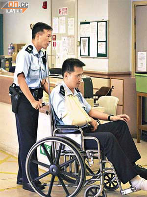 受傷警員送院時需坐上輪椅。	（陳桂建攝）