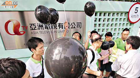 十多名政黨的成員手持黑色氣球到亞視總部請願。	（陳德賢攝）