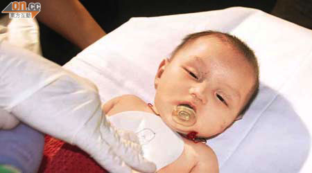 嬰兒送院時，救護員仍不斷為其急救。（李少雄攝）