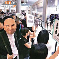 示威者戴上蘋果公司前行政總裁喬布斯面具，諷刺他並非神，呼籲消費者不要盲目膜拜。