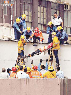 消防員由簷篷將跳樓男子抬下。	（曾紹良攝）