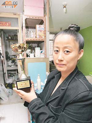 曾萌死念的前亞視女藝員白淑貞展示奪得內地歌唱比賽銅獎的獎盃。	（周宏杰攝）