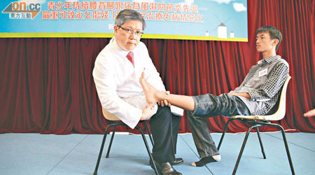 李子良（左）與施名謙（右）示範檢查腳跟發炎情況。