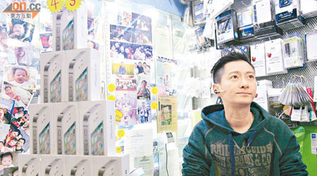 手機店負責人劉志剛指iPhone 4S的收購價分分鐘不同。（甘偉倫攝）