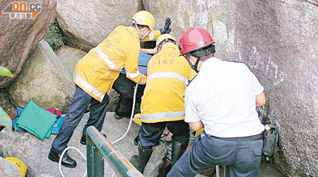 消防員用繩伸入張保仔洞，拯救被困男子。（黃子源攝）