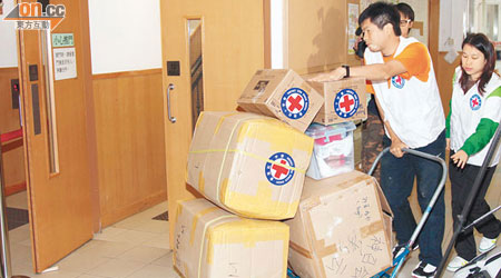 紅十字會工作人員運送棉被及日用品到中心，供災民使用。