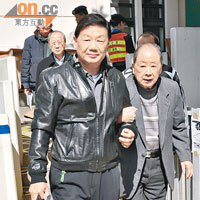 胡法光（右）由胡曉明攙扶，去票站投票。