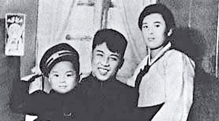 金正日兒時與父親金日成（中）、母親金正淑（右）合照，還笑着打扮成軍人。（黑白圖片）