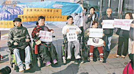 有殘疾人士手持「見你一面、難過登天」標語在會場外抗議。（溫國佳攝）
