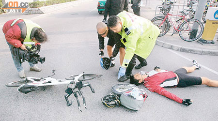 受傷單車發燒友倒臥現場，損毀的名貴單車翻在身旁。（黃智康攝）