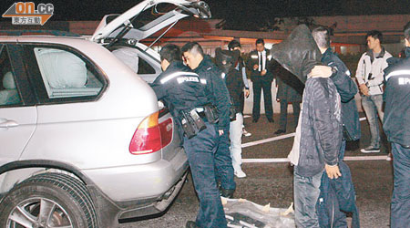 兩名涉偷車男子被蒙頭押返現場調查。（王偉安攝）