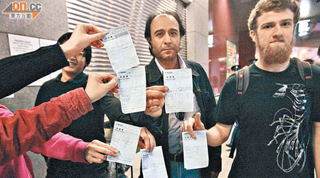 多名外籍人士展開領取簽證的收據。（王譯揚攝）