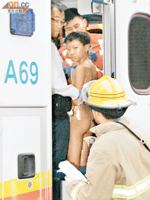 被燒傷的男童接受救護員初步敷治後再送院治療。（黃君堡攝）
