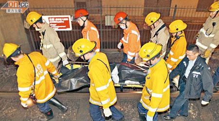 消防員將跳軌男子屍體抬離路軌。（左蘭慶攝）