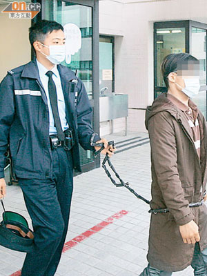 涉冒警行劫被捕兩名青年送院檢驗後，由警員用鐵鏈押返警署調查。（麥少峰攝）