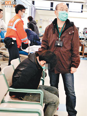 被捕男子坐於急症室等候治理，由關員看守。（冼耀華攝）