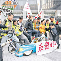 遊行人士踩爛一架代表內地車輛的「左軚紙紮車」，反對自駕遊計劃。