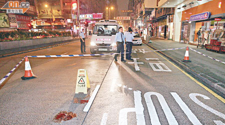 警員封鎖一段彌敦道調查男生墮樓原因，現場路面遺下一攤血漬。（張曉楠攝）