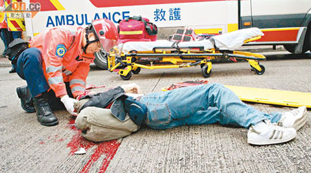 陳燦基被夾爆胸吐血，救護員替他急救。 （讀者提供）