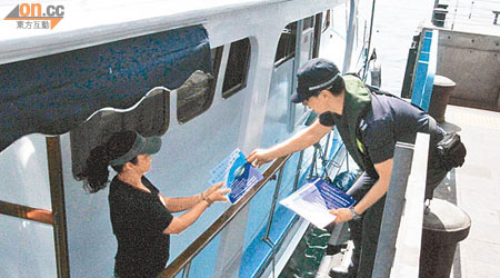 水警昨在西貢碼頭向遊艇負責人派發水上安全宣傳單張。