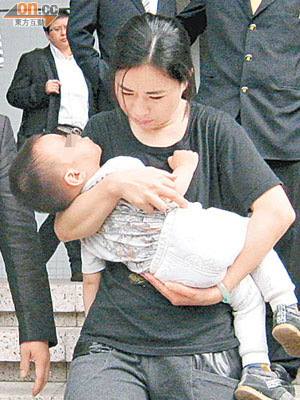 女被告羅曉霞昨應訊後抱着兒子離開。