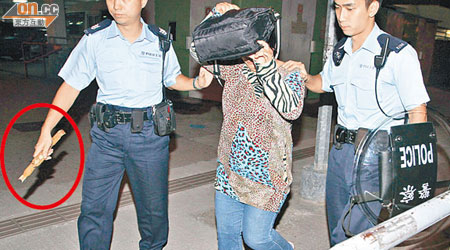 女事主母親被捕帶署，警方檢走斷開兩截的「不求人」（圓圈示）。