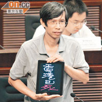 市民譚國新手持「香港已死」標語默哀，抗議方案是「政治豆腐渣工程」。