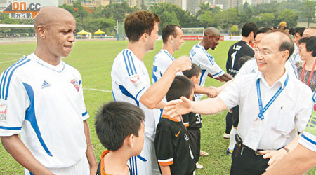 身為屯門足球隊會長嘅陳強（右一），開賽前同球員握手。（許紹基攝）