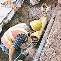 工人用工具剷走積存在煤氣喉內的沙泥。（黃智康攝）