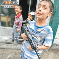 Ｏ九年新疆騷亂後，烏魯木齊有兒童持玩具槍上街。（資料圖片）