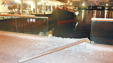 岸上玻璃圍欄被撞毀，滿地碎片，漁船駛回碼頭助查。（蘇仲賢攝）