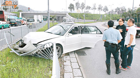 警員在被偷私家車失事撞欄現場調查。（楊日權攝）
