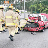 的士車尾毀如廢鐵，消防員檢查車內石油氣缸。