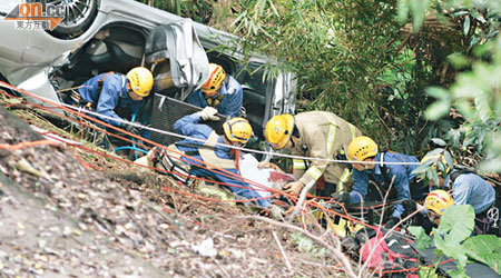 消防員從「反肚」的車廂內救出被困司機。（馬竟峯攝）