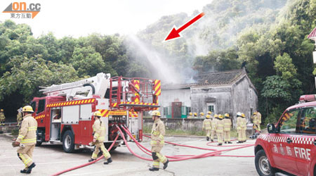 消防開喉射穿石屋屋頂，噴出水柱（箭嘴示）。（邱國賢攝）