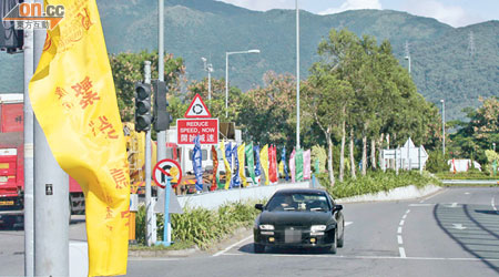 錦田公路一帶近日插滿五彩繽紛的旗幟，被指危害交通安全。（李健瑜攝）