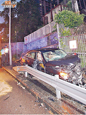 剷上行人路的房車夾於牆壁與鐵欄之間，損毀嚴重。（張曉楠攝）