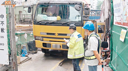 警員在港鐵地盤門口，抽驗懷疑長度逾十米的車輛。