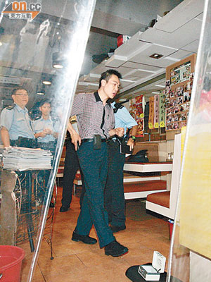 東主在店內協助警方調查，載小費的錢箱被棄在地上。（楊偉嶽攝）