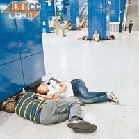 乘客因無車返家，加上疲憊不堪，在大圍站大堂席地而睡。（吳建明攝）