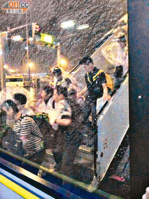 國泰竟要乘客冒着狂風大雨走出機艙，乘搭接駁巴士。（讀者提供）