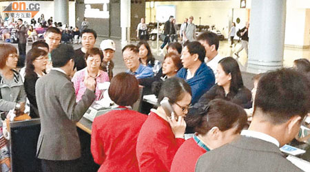 大批滯留在機場禁區的旅客不滿航班連番延誤，一度鼓譟。（讀者提供）