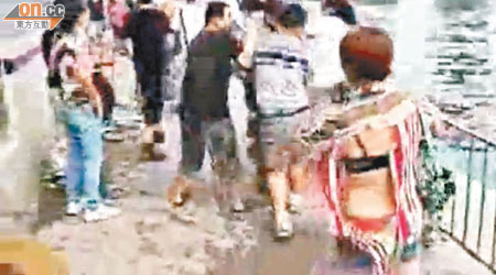 疑似北京女導遊（右）在混亂中被撕破上衣，露出背部及胸圍。