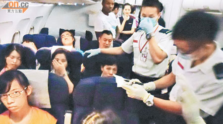 救護員進入國航機艙為不適乘客進行初步治理。（讀者提供）
