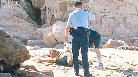 警員在石灘檢查男屍及調查。（黃子源攝）