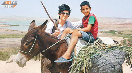 項明生（左）喺摩洛哥巧遇騎驢嘅牧童，兩人笑容一樣咁童真。（受訪者提供）