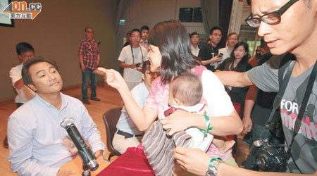 葉女士抱着嬰兒，指罵李啟榮是「人肉錄音機」。（胡家豪攝）